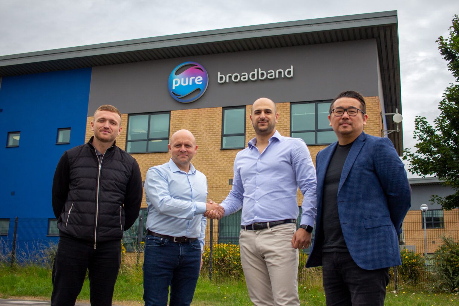 Furqan and Alex shaking hands with Pure Broadband owners in order to acquire the company